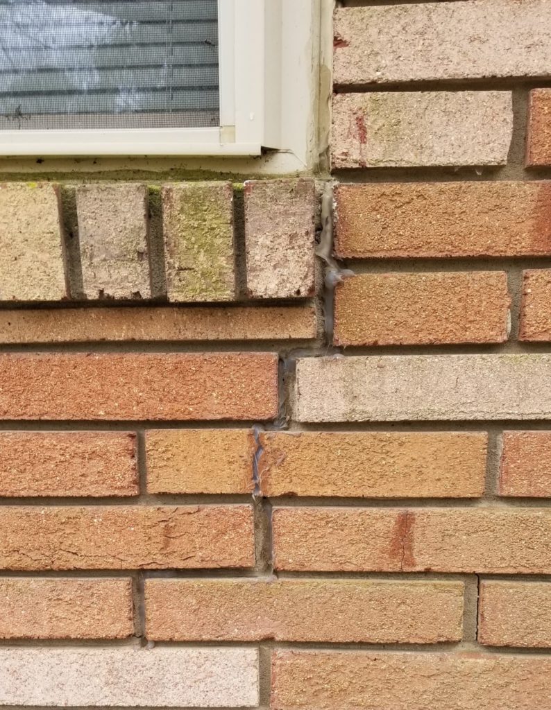 Step crack in brick veneer sealed by home owner